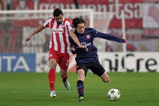 Olympiakos Giannis Maniatis fights for the ball with Arsenal's Tomas Rosicky (R)